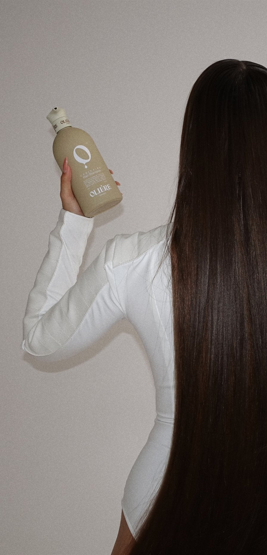 Oli&egrave;re Paris shampoo and hair mask held up behind long hair
